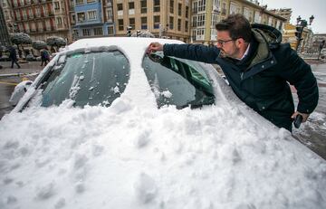 Un hombre quita la nieve de su coche en Burgos, Castilla y León (España). La provincia está en alerta debido a que la cota de nieve ha bajado a los 400 metros y se esperan nevadas generalizadas. 