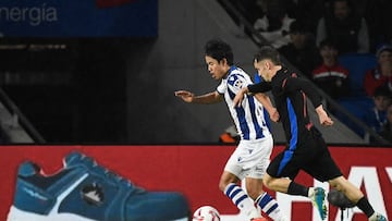 Real Sociedad's Japanese forward #14 Takefusa Kubo (L) runs with the ball challenged by Barcelona's Spanish midfielder #17 Marc Casado during the Spanish league football match between Real Sociedad and FC Barcelona at the Anoeta stadium in San Sebastian on November 10, 2024. (Photo by ANDER GILLENEA / AFP)