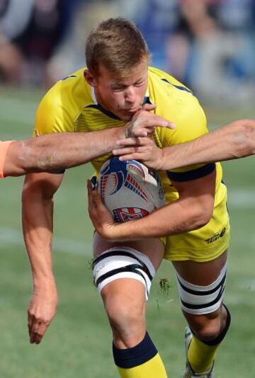 Cameron Clark de Australia es golpeado por dos jugadores de Argentina durante el torneo de Sevens Rugby en Sam Boyd Stadium en EEUU.