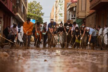 Un grupo de voluntarios ayudan a limpiar las calles de Massanassa, España.