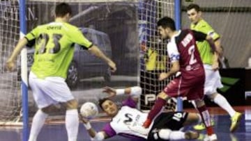 El jugador del Caja Segovia David rematando ante el portero Juanjo en presencia de Ortiz, ambos del Inter Movistar, durante el partido de los cuartos de final de la Copa de Espa&ntilde;a disputado esta noche en en el Pabell&oacute;n Caja Madrid de Alcal&aacute; de Henares, en Madrid. 