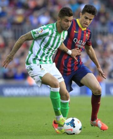 El defensa del FC Barcelona Marc Bartra (d) disputa un balón con el delantero del Real Betis Álvaro Vadillo (i).