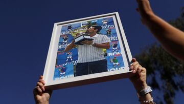 A supporter of Serbian tennis player Novak Djokovic holds his photo during a rally outside the Park Hotel, where the star athlete is believed to be held while he stays in Australia, in Melbourne, Australia, January 9, 2022. REUTERS/Loren Elliott