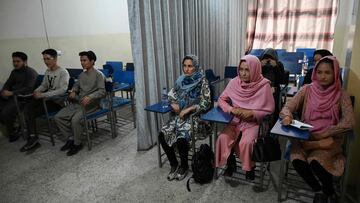 Students attend a class bifurcated by a curtain separating males and females at a private university in Kabul on September 7, 2021, to follow the Taliban's ruling. (Photo by Aamir QURESHI / AFP)