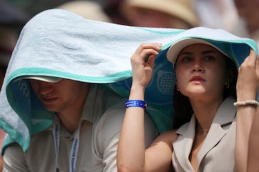 Los espectadores se protegen del sol mientras observan a Barbora Krejcikova, de la República Checa, y Alexandra Eala, de Filipinas, durante su partido individual femenino de primera ronda en el Campeonato de Tenis de Wimbledon en Londres.