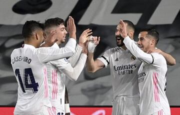 TOPSHOT - Real Madrid's French forward Karim Benzema (2R) celebrates with teammates after scoring during the "El Clasico" Spanish League football match between Real Madrid CF and FC Barcelona at the Alfredo di Stefano stadium in Valdebebas, on the outskir