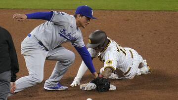 Los Angeles Dodgers shortstop Corey Seager, left, drops the ball as San Diego Padres' Manny Machado safely steals second base during the ninth inning of a baseball game Friday, April 16, 2021, in San Diego. (AP Photo/Gregory Bull)