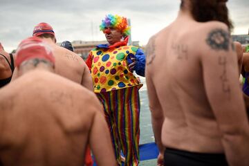 A participant in a clown suit waits for taking part in the 108th edition of the 'Copa Nadal' (Christmas Cup) swimming competition in Barcelona's Port Vell on December 25, 2017.  
The traditional 200-meter Christmas swimming race gathered more than 300 participants on Barcelona's old harbour.   / AFP PHOTO / Josep LAGO