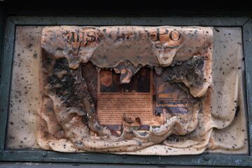 Una caja de periódico 'Palidades Post' derretida muestra mientras el incendio Palisades arrasa un vecindario en medio de fuertes vientos en el barrio Pacific Palisades.