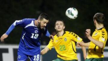 Los jugadores de Lituania Fedor Cernych y Deivydas Matulevicius  pelean por el control del bal&oacute;n contra Haris Medunjanin de la selecci&oacute;n de Bosnia, durante el partido de clasificaci&oacute;n para el Mundial de Brasil 2014 que ambas selecciones han disputado en Kaunas, Lituania, el 15 de octubre de 2013. 