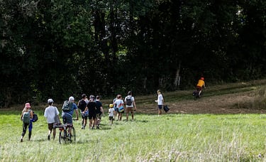 Un grupo de aficionados regresa después de contemplar el paso de los corredores durante la etapa al sprint.