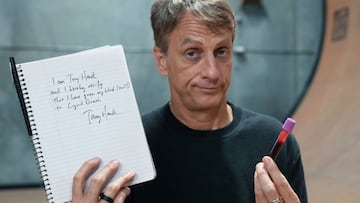 El skater Tony Hawk, en su halfpipe, mostrando un potecito con su sangre en una mano y en la otra un escrito en el que certifica que se ha usado para pintar una tabla de skate.