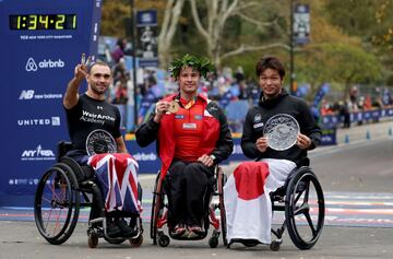 El corredor suizo Marcel Hug celebra la victoria de la carrera de Profesionales en Silla de Ruedas junto al británico John Charles Smith y el japonés Sho Watanabe.