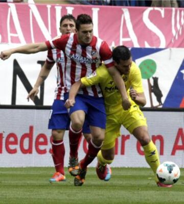 El centrocampista del Atlético de Madrid "Koke" Resurrección (c) disputa un balón con el delantero francés del Villarreal Jérémy Perbet (i).