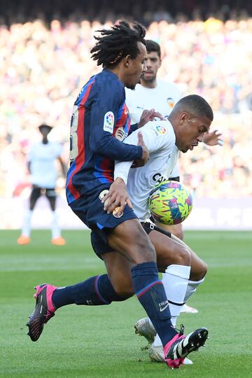 El defensa del Barcelona Jules Kounde intenta evitar el control del balón del jugador del Valencia CF Samuel Lino. 
