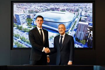 Kepa Arrizabalaga y Florentino Pérez posan estcehando las manos delante de una imagen de la maqueta del Nuevo Bernabéu.