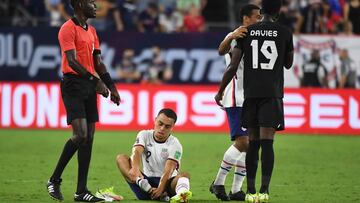 Sergiño Dest se duele de un golpe en el tobillo durante un partido con Estados Unidos.