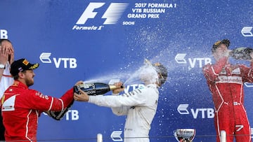 Winner Finnish Formula One driver Valtteri Bottas of Mercedes AMG (C), second-placed German Formula One driver Sebastian Vettel of Scuderia Ferrari (L), and third-placed Finnish Formula One driver Kimi Raikkonen of Scuderia Ferrari (R) celebrate with cham