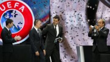 Ribéry se dispone a recoger el premio de manos de Platini, bajo la atenta mirada de Messi.