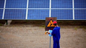 FILE PHOTO: A worker inspects solar panels at a solar farm in Dunhuang, 950km (590 miles) northwest of Lanzhou, Gansu Province September 16, 2013. REUTERS/Carlos Barria/File Photo
