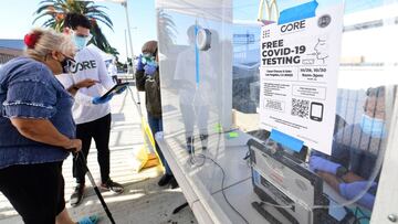 A woman about to take her test goes over details on her paperwork with a volunteer at a pop-up Covid-19 Test site in Los Angeles, California on October 29, 2020, where the testing is walk-up only with no appointments necessary and results in 48 hours. - W