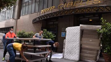 Voluntarios recogen las camas y colchones donados por el hotel Tryp Cibeles, de Madrid, para familias desfavorecidas que sufren los efectos de la crisis provocada por el COVID-19.