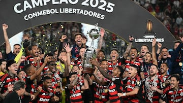 Flamengo's forward #27 Bruno Henrique (R) and Uruguayan midfielder #10 Giorgian de Arrascaeta (L) lift the the trophy with teammates after winning the all Brazilian Copa Libertadores final football match between Palmeiras and Flamengo at Monumental 'U' Marathon stadium in Lima on November 29, 2025. (Photo by Luis ACOSTA / AFP)
