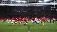 Los jugadores del Sevilla corren hacia el trofeo de campeones de la Europa League.