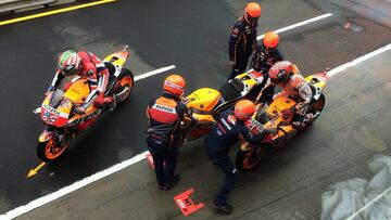 Los mecánicos de Márquez con casco en el pit lane.