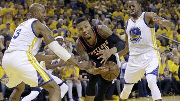 Portland Trail Blazers guard Damian Lillard, center, loses the ball between Golden State Warriors forward David West (3) and forward Andre Iguodala (9) during the second half of Game 1 of a first-round NBA basketball playoff series in Oakland, Calif., Sunday, April 16, 2017. The Warriors won 121-109. (AP Photo/Jeff Chiu)