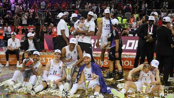 Real Madrid's players celebrate with the trophy and some fanily members after winning the Euroleague basketball final four final match between Olympiacos Piraeus and Real Madrid in Kaunas, on May 21, 2023. (Photo by PETRAS MALUKAS / AFP)