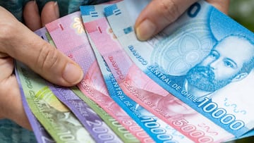 Woman holding Chilean money, Various peso banknotes, House budget concept
