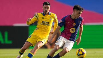 BARCELONA, 30/11/2024.- El centrocampista del Barcelona Pedri (d) pelea un balón con el centrocampista Javi Muñoz, de Las Palmas durante su partido de LaLiga en el Estadio Olímpico Lluís Companys en Barcelona este sábado. EFE/Enric Fontcuberta