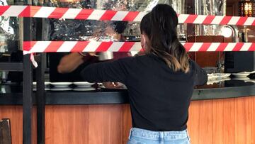 GRAF8161. MADRID (ESPA&Ntilde;A), 21/09/2020.- Una camarera se prepara para llevar el pedido a una mesa delante de las cintas que advierten de que la barra de la cafeter&iacute;a del hostal Don Pedro, al lado de hospital Gomez Ulla, en el barrio de Vista 