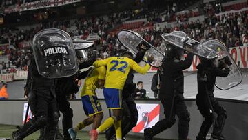 Boca Juniors' Colombian forward Sebastian Villa (22) and midfielder Juan Ramirez leave the field under police shield after defeating River Plater 1-0 in their Argentine Professional Football League match at the Monumental stadium in Buenos Aires, on March 20, 2022. (Photo by JUAN MABROMATA / AFP)