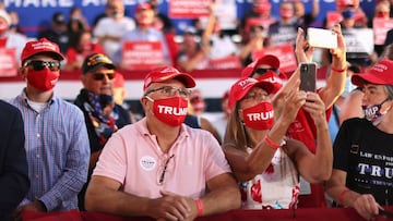 Supporters wearing face masks due to the ongoing coronavirus outbreak look on as Donald Trump holds a campaign rally in Londonderry, New Hampshire.