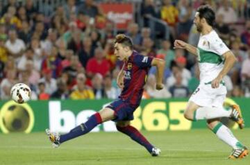 El delantero del Barcelona Munir El Haddadi Mohamed (i) marca su gol, el segundo del equipo, superando al defensa del Elche, Sergio Pelegrín (d), durante el partido de la primera jornada de la Liga de Primera División que se juega hoy en el Camp Nou.