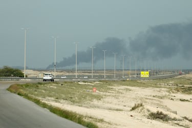 Los vehículos circulan por una carretera mientras se elevan columnas de humo desde la refinería de petróleo Ras Tanura.