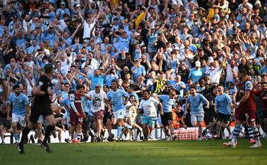 Manchester City fans invade the pitch to celebrate their team's win, after the English Premier League football match between Manchester City and West Ham United at the Etihad Stadium in Manchester, north west England, on May 19, 2024. Manchester City created English football history on Sunday, beating West Ham 3-1 to win an unprecedented fourth straight Premier League title. (Photo by Oli SCARFF / AFP) / RESTRICTED TO EDITORIAL USE. No use with unauthorized audio, video, data, fixture lists, club/league logos or 'live' services. Online in-match use limited to 120 images. An additional 40 images may be used in extra time. No video emulation. Social media in-match use limited to 120 images. An additional 40 images may be used in extra time. No use in betting publications, games or single club/league/player publications. / 
