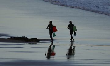 Dos surfistas en la playa vizcaína de Sopelana, se dirigen a realizar surf, tras 49 días de confinamiento. Desde este sábado, las personas mayores de 14 años pueden ir a pasear y hacer deporte individual, respetando unos horarios y la distancia de seguridad, unas salidas que se suman a los paseos de los niños que comenzaron a estar permitidos el pasado domingo tras semanas de confinamiento por el coronavirus. 