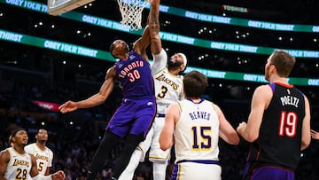 Nov 10, 2024; Los Angeles, California, USA; Toronto Raptors guard Ochai Agbaji (30) attempts to block Los Angeles Lakers forward Anthony Davis (3) during the first half at Crypto.com Arena. Mandatory Credit: Jonathan Hui-Imagn Images