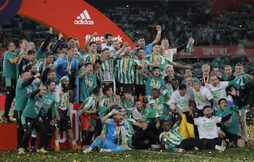 Los jugadores del Betis campeones de Copa celebran en el césped su triunfo.