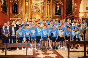Los jugadores del Málaga posan tras la ofrenda floral en la Parroquia de la Divina Pastora en el barrio de Capuchinos.