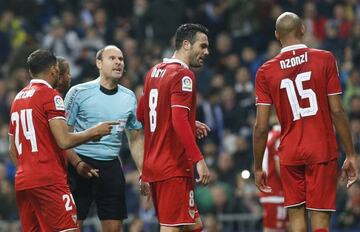 Sevilla's players argue with referee Antonio Mateu Lahoz.