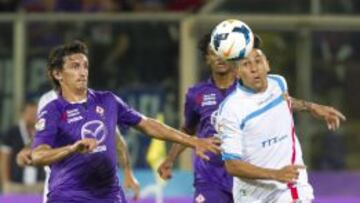 El jugador de la Fiorentina Stefan Savic disputa el bal&oacute;n con Lucas Castro del Catania.