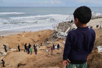 Palestinos inspeccionan los escombros de una estructura impactada por un bombardeo israel en Deir al-Balah, Franja de Gaza.