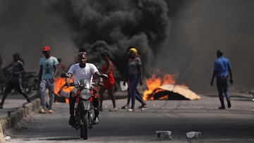 A man drives past a burning barricade during a protest against Prime Minister Ariel Henry's government and insecurity, in Port-au-Prince, Haiti March 1, 2024. REUTERS/Ralph Tedy Erol