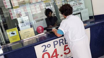 Una mujer acude a un puesto de lotería para comprar su boleto.