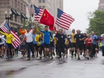 Los corredores llevan banderas cuando se acercan a la línea de meta después de completar el último kilómetro del recorrido de la Maratón de Boston. El evento fue organizado para dar a los atletas y espectadores la oportunidad de completar el último kilómetro de la Maratón que se vio truncada cuando dos bombas explotaron en la línea de meta.