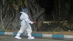 A health worker wearing a protective suit walks in a police station to collect swab samples from police officials to test for the COVID-19 coronavirus, in Kolkata on July 28, 2020. (Photo by Dibyangshu SARKAR / AFP)
